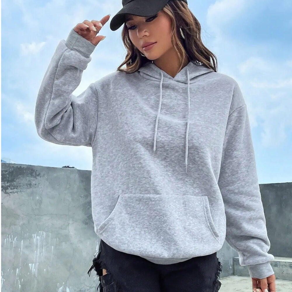 0-001616.jpeg Femme portant un pull gris à capuche et une casquette.