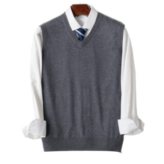 Pull sans manche gris sur chemise blanche posés sur un ceintre.