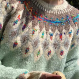 Pull jaquard vert claire avec des motifs roses, verts et bleus