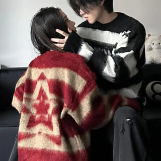 Une femme avec pull rouge et un homme avec un pull noir qui se regardent