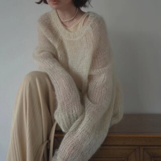 Femme portant un pull long et ample beige.