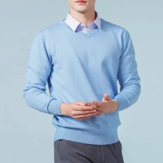 Pull bleu ciel col en V porté par un homme avec une chemise blanches et un pantalon gris