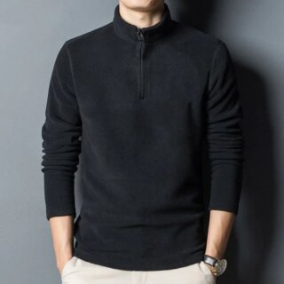 Homme portant un pull polaire noir sur fond gris.