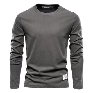 On voit un sous-pull gris foncé manches longues col rond sur fond blanc.