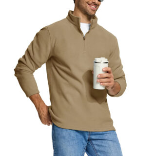 Homme portant un pull marron et tenant un mug blanc.