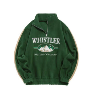 On voit un pull vintage pour homme vert, avec un message WHISTLER sur le devant et un dessin de montagne. Le pull est vert et en polaire.