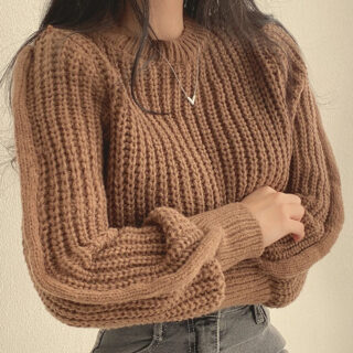 Femme portant un pull marron large.