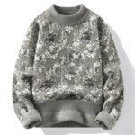 Pull gris avec des fleurs blanches sur fond blanc.