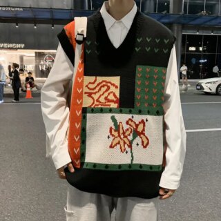 Homme portant un pull sans manche et se trouvant dans la rue.