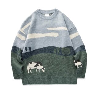 On voit un pull en maille pour homme avec un motif paysage représentant une prairie et des vaches qui broutes. C'est un pull rétro et moche.