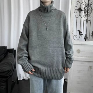 Homme portant un pull long gris à col roulé.
