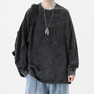 Homme portant un pull noir long sur fond blanc.