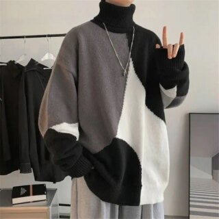 Homme portant un pull long noir, blanc et gris.