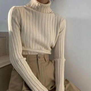 Femme portant un pull beige à col roulé.