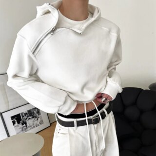 On voit un homme qui porte un pull court zippé blanc tendance avec un jean slim blanc.