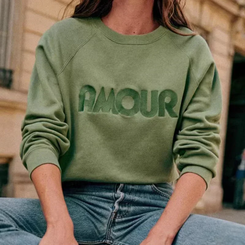 Photo d'une femme portant un pull amour vert avec un jean.