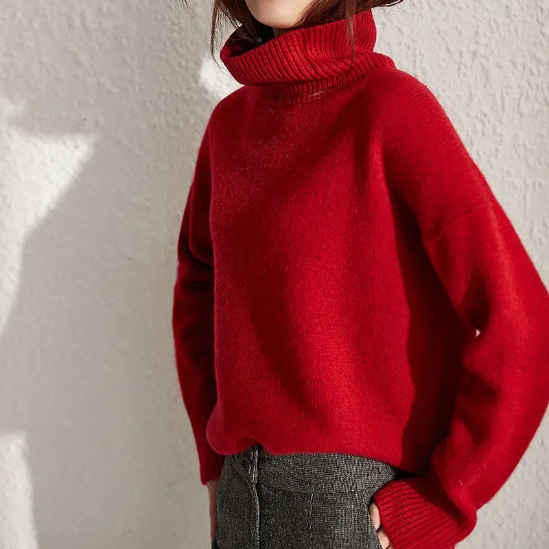 Femme portant un pull rouge col roulé.