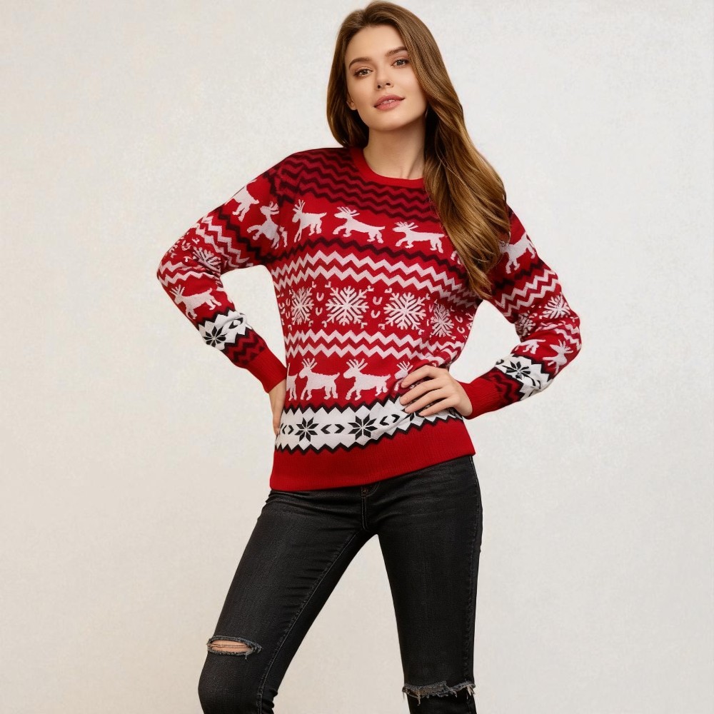 Femme caucasienne châtain clair vêtu d'un jean noir et d'un pull de Noël principalement rouge avec motifs festifs et traditionnels blanc et noir de rennes et flocons de neige sur fond uni.